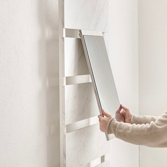 突っ張りミラー付きラックに鏡を取り付けようとしている様子