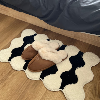 ブラウンのムートン調のファースリッパをミニラグの上に置いている様子