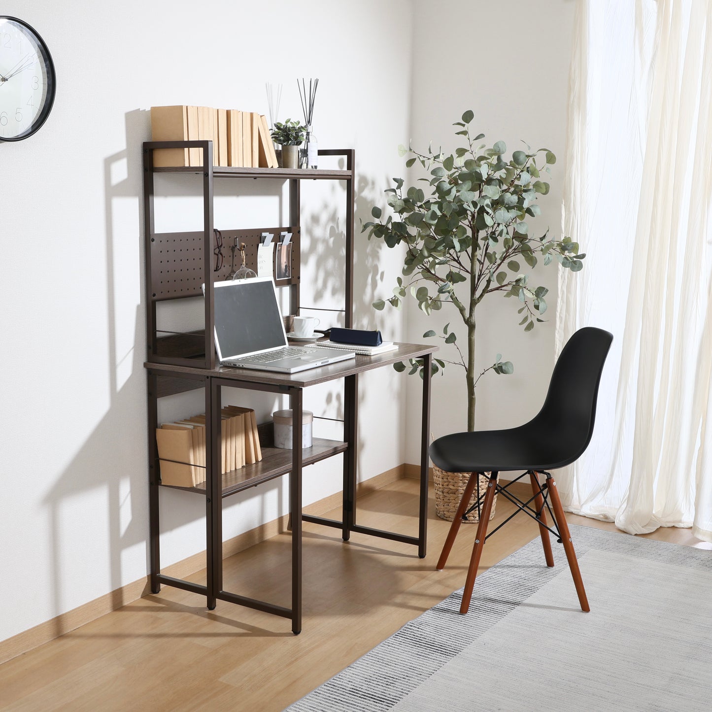 天板が折りたためる収納棚が付いたデスクにパソコンや本が置かれている様子