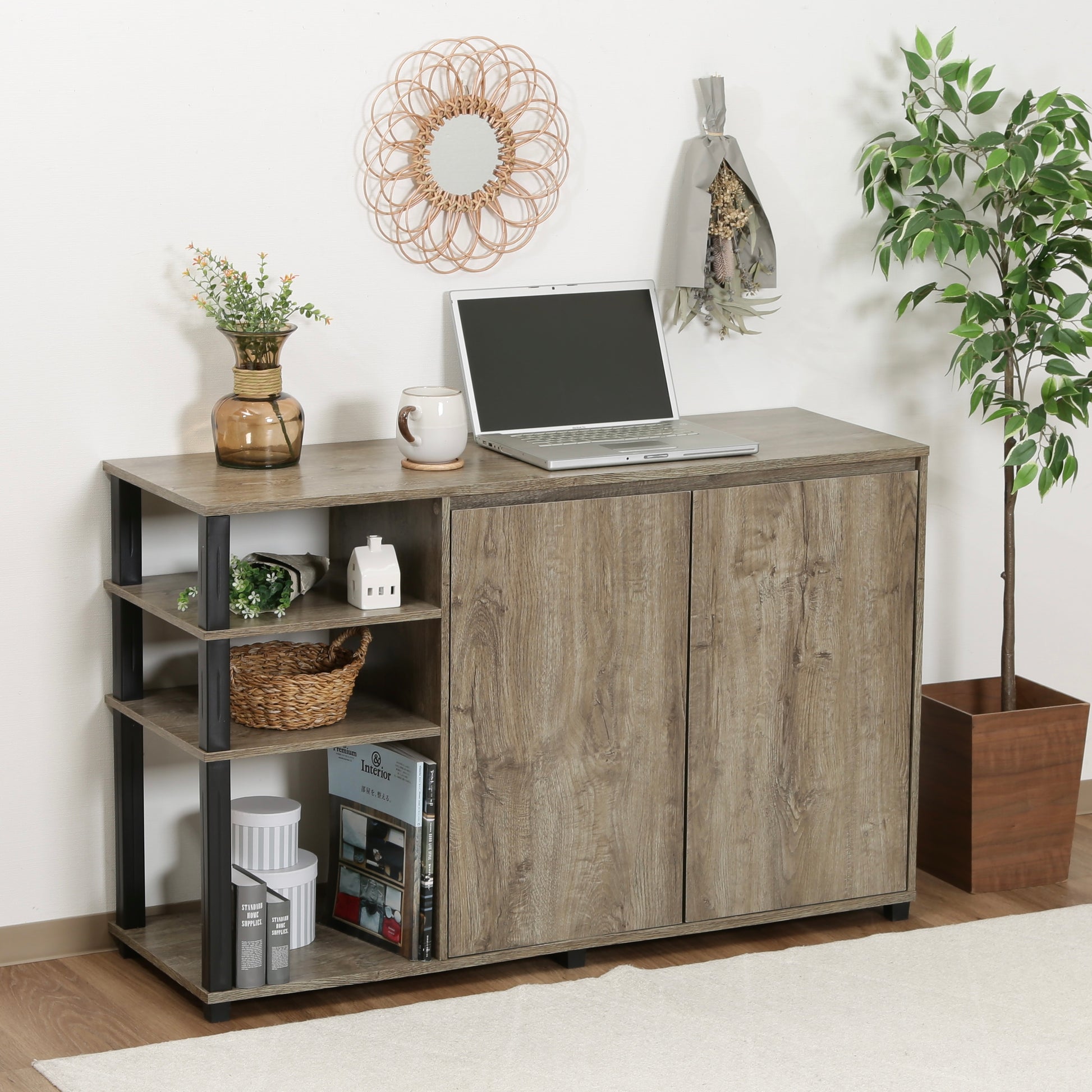 オープンラックが一体になった、ウッド素材のキャビネットの上にパソコンや植物が置かれている様子