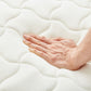 ホワイトのポケットコイルマットレスに手を置いている様子