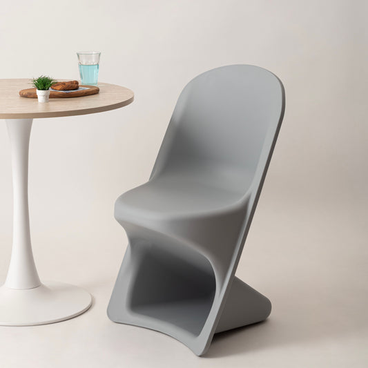 ユニークなデザインのスタッキング可能なチェアがテーブルの前に置かれている様子