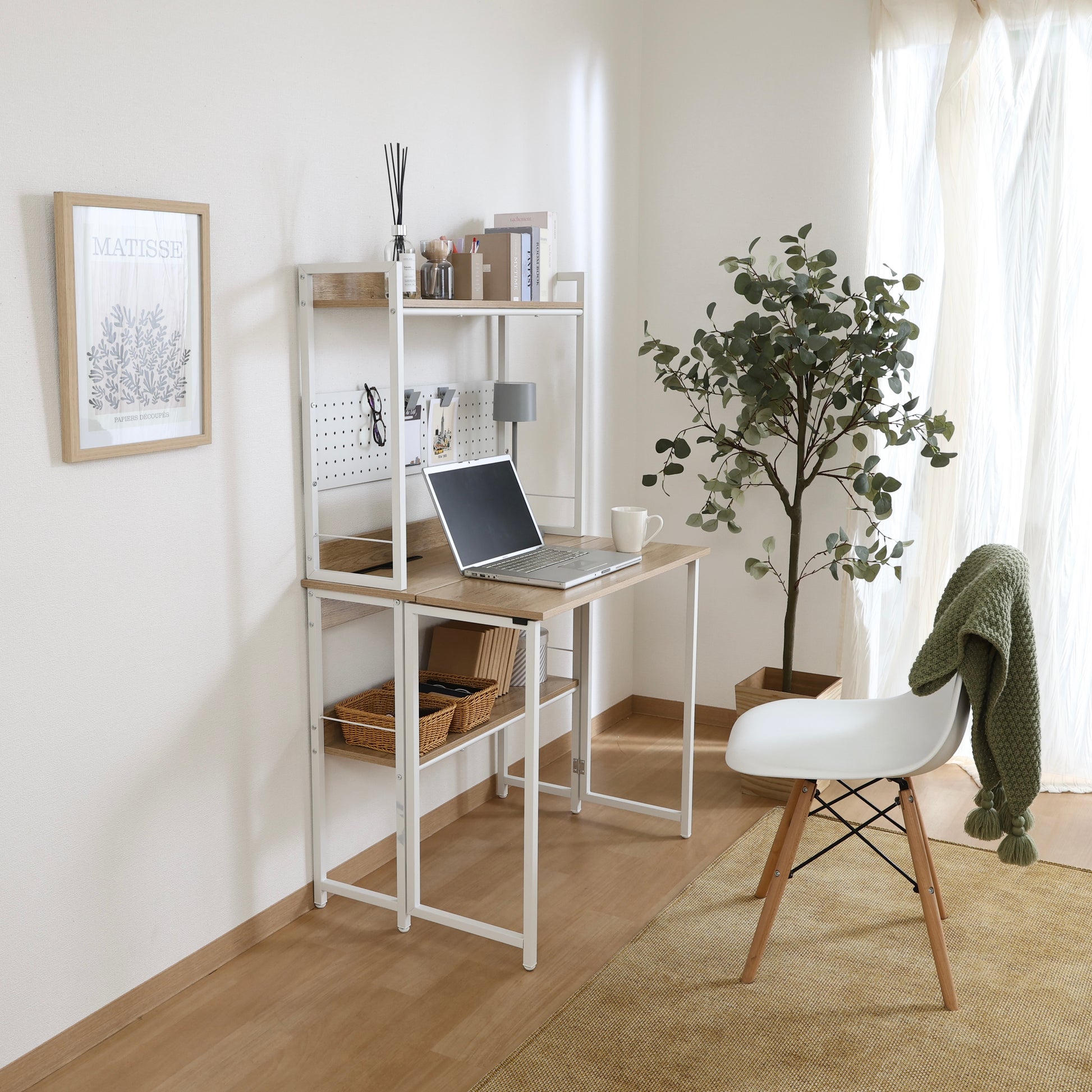 天板が折りたためる収納棚が付いたデスクにパソコンや本が置かれている様子