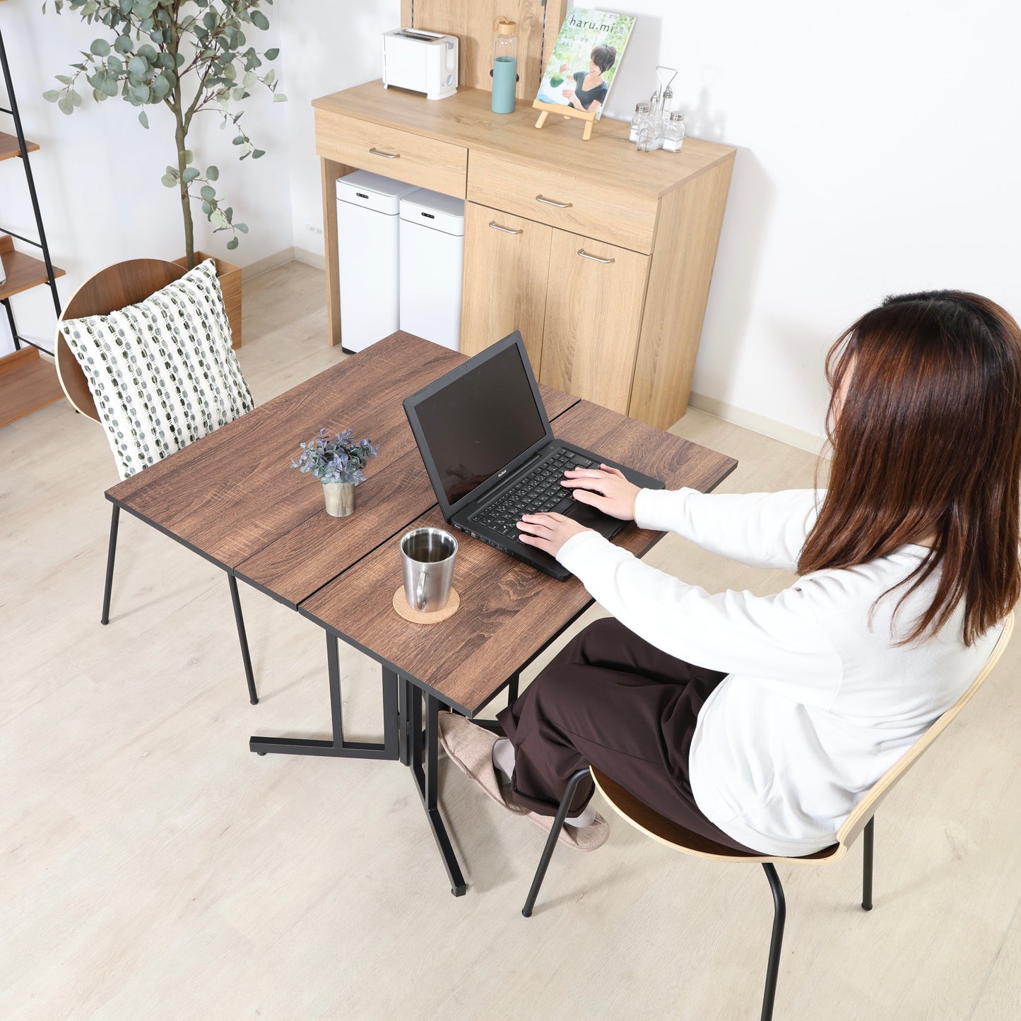 ウッド天板とスチール脚の異素材組み合わせの折りたたみ式のダイニングテーブルが置かれている様子