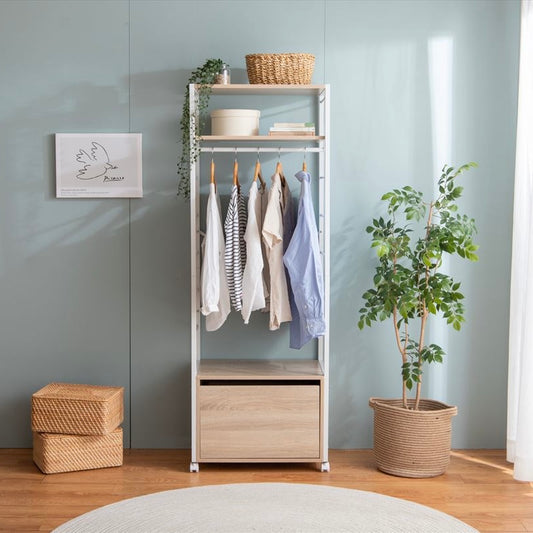 引き出し付きのナチュラルカラーのハンガーラックがリビングに置かれている様子