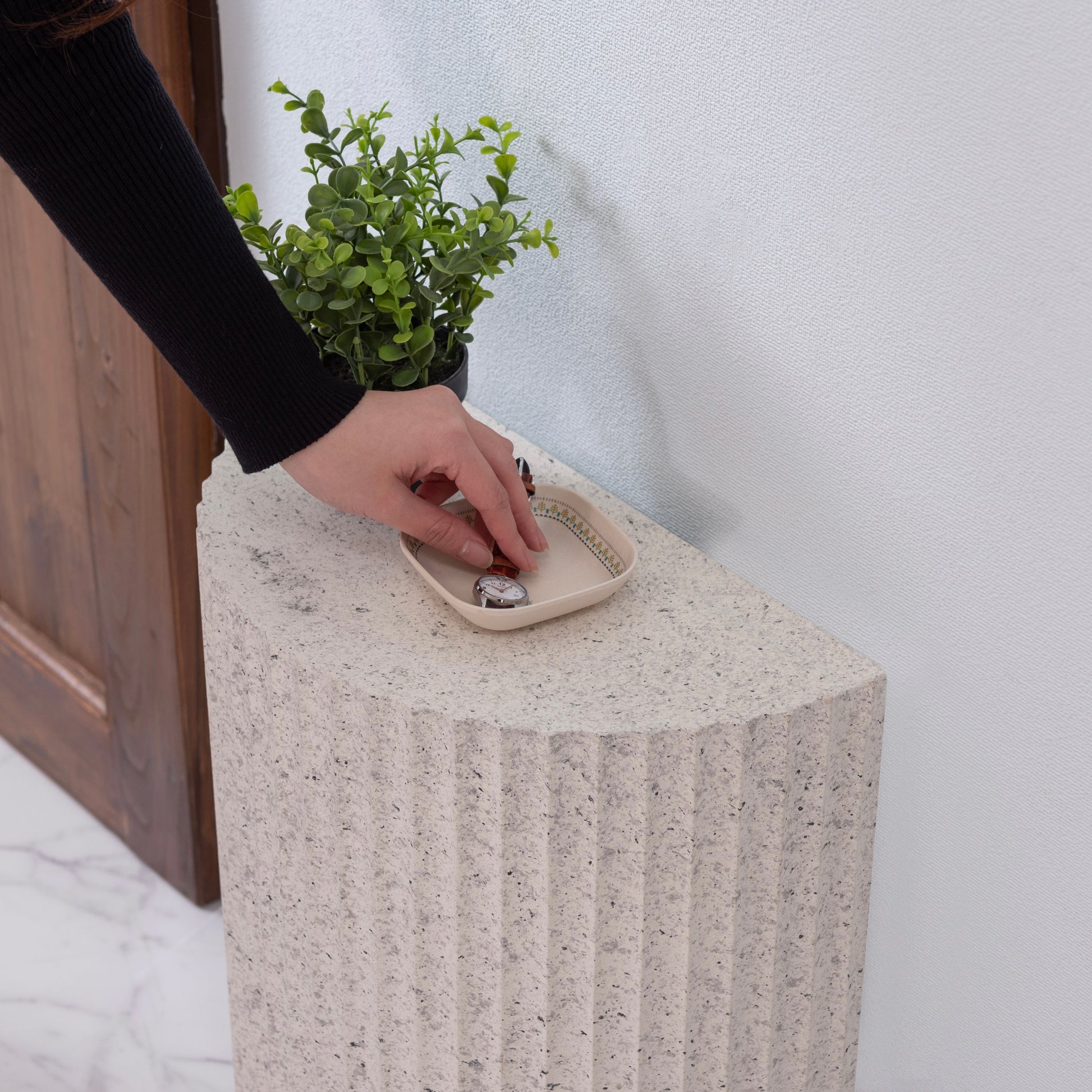 テラゾー柄の半円のスツールが玄関に置かれている様子