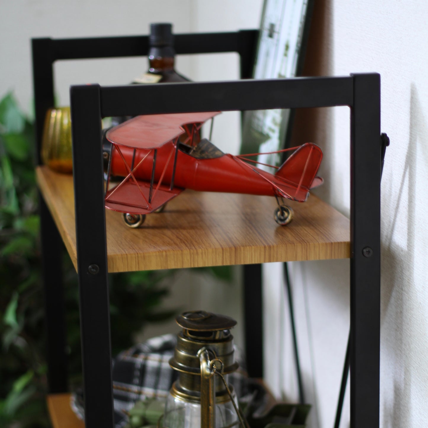 ウッド素材の天板と黒スチールのフレームの4段シェルフにお気に入りのアイテムが飾られている様子