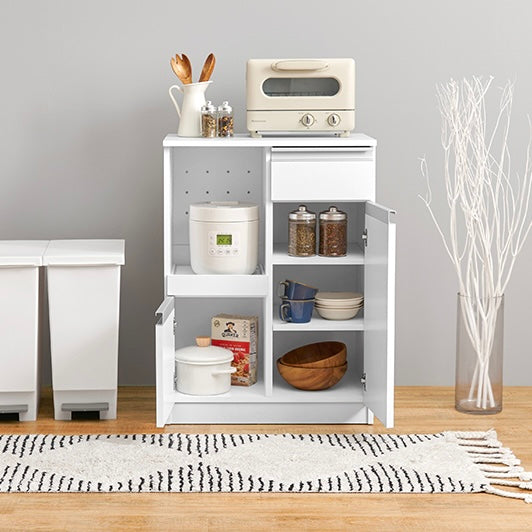 ホワイトのキッチンボードに調理器具やストック品が収納されている様子