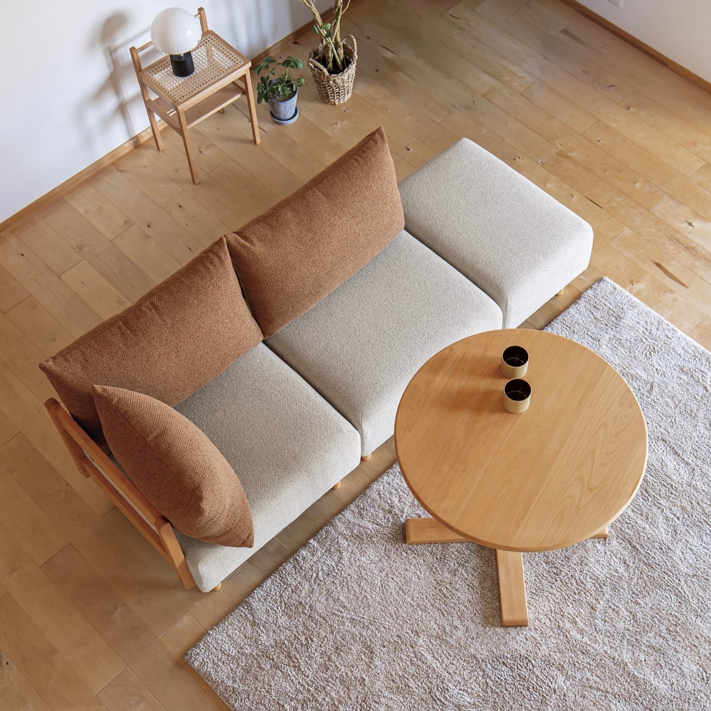 木製フレームのテラコッタオレンジのソファがリビングに置かれている様子