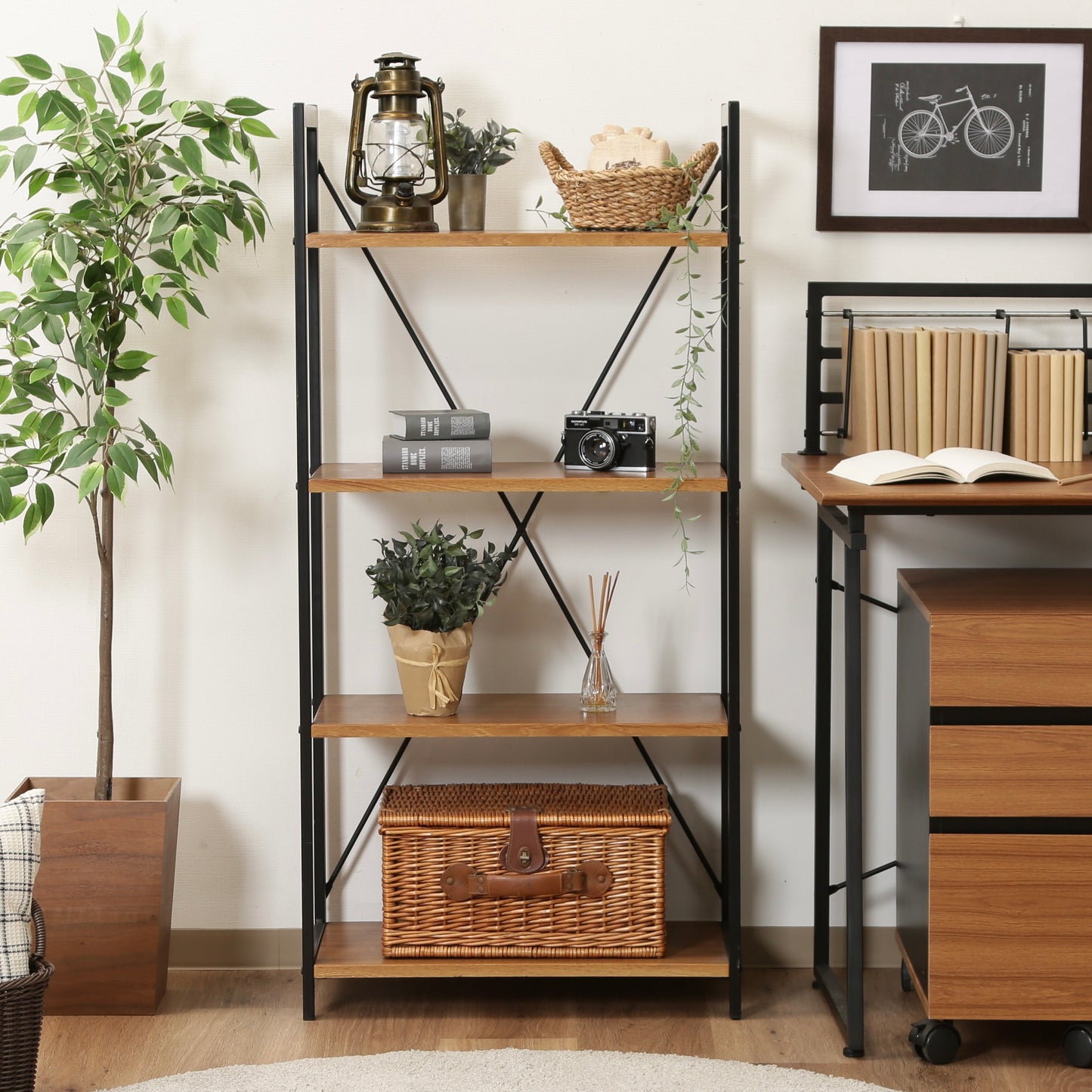 ウッド素材の天板と黒スチールのフレームの4段シェルフがデスク横に置かれている様子