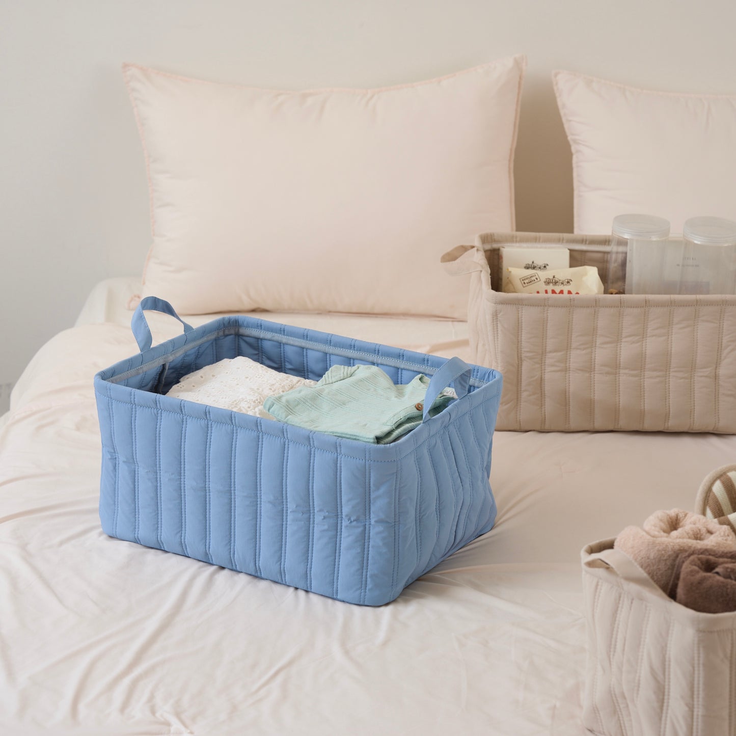 キルティング素材のブルーのバスケットに子供服が収納されている様子