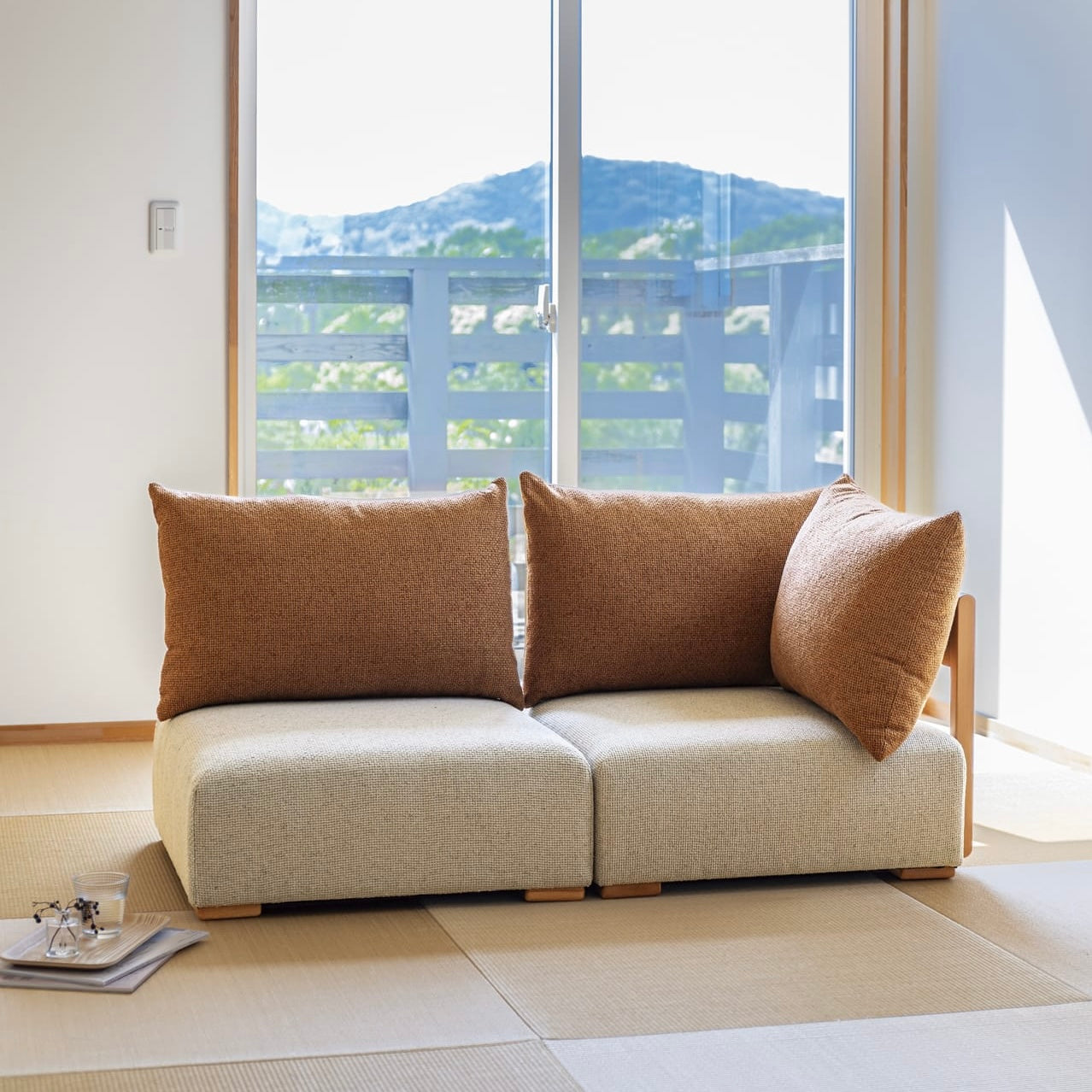 木製フレームのテラコッタオレンジのソファが畳の部屋に置かれている様子