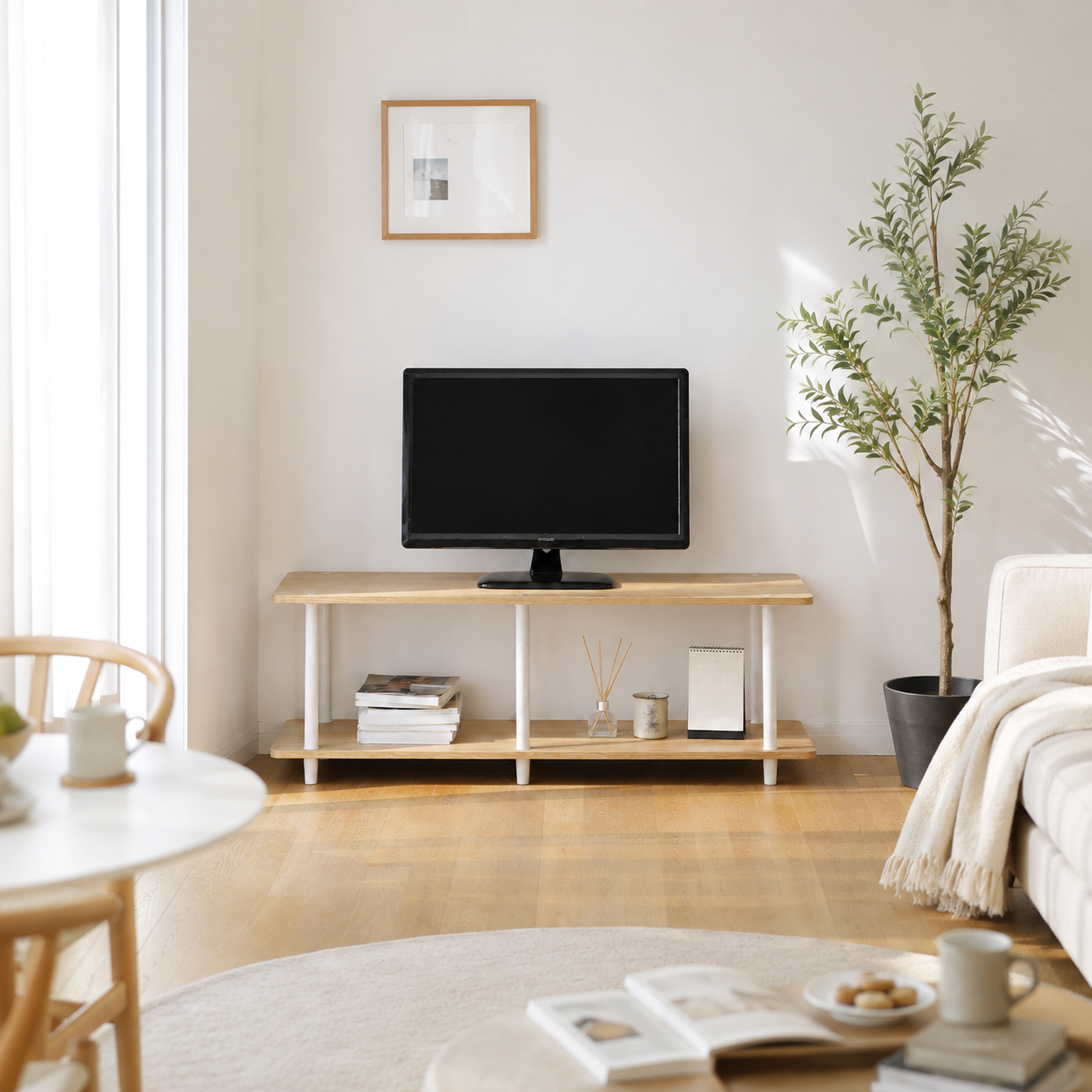 黒いフラットスクリーンテレビが置かれた組立式リビングボードのライトウッド製テレビ台