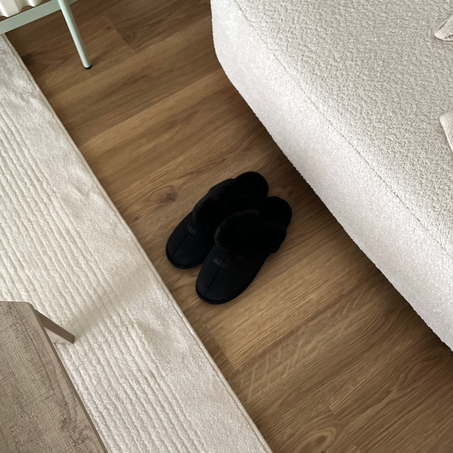 ブラックのムートン調のファースリッパをソファ前に置いている様子