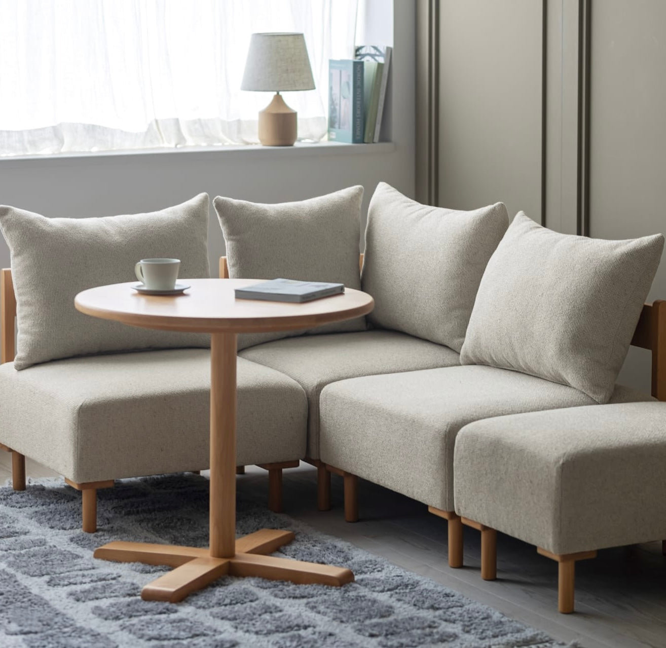 木製フレームのベージュのソファがリビングに置かれている様子