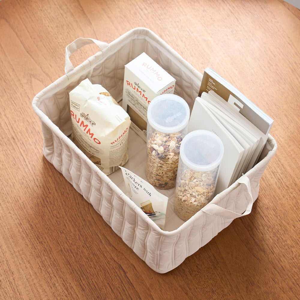 キルティング素材のベージュのバスケットに食料品が収納されている様子