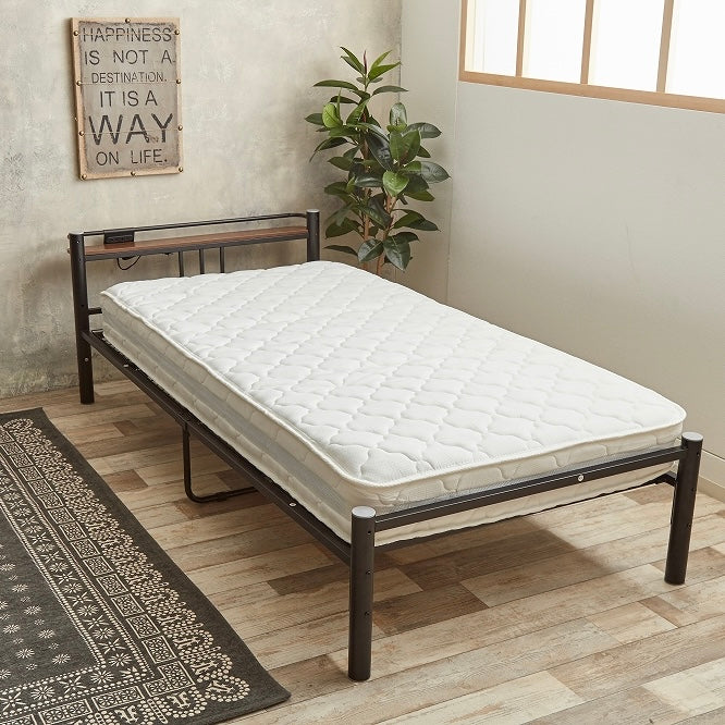 ホワイトのポケットコイルマットレスをベッドの上に置いている様子