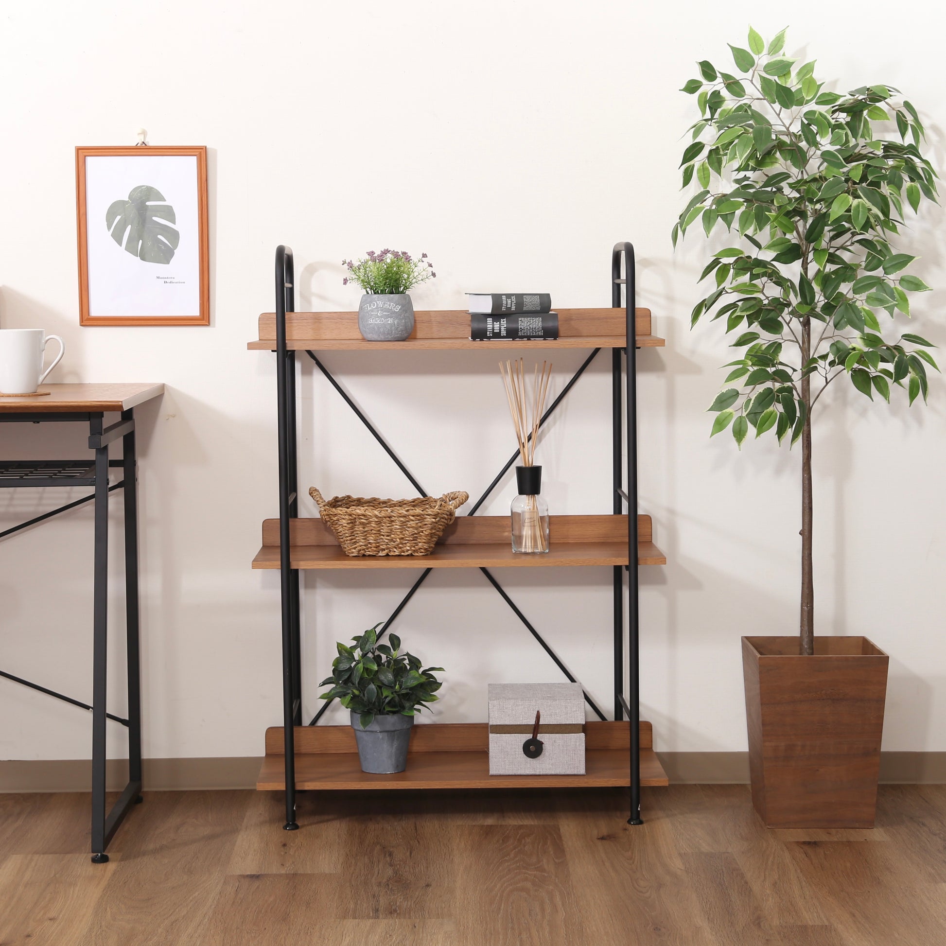 ウッド素材とブラックフレームの3段のオープンシェルフがデスク横に置かれている様子