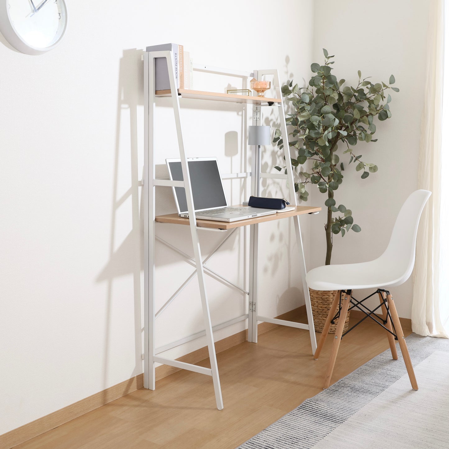 収納棚が付いた折りたたみ式のデスクにパソコンや本が置かれている様子