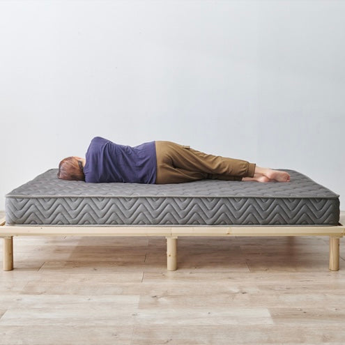 グレーのポケットコイルマットレスに横たわっている様子
