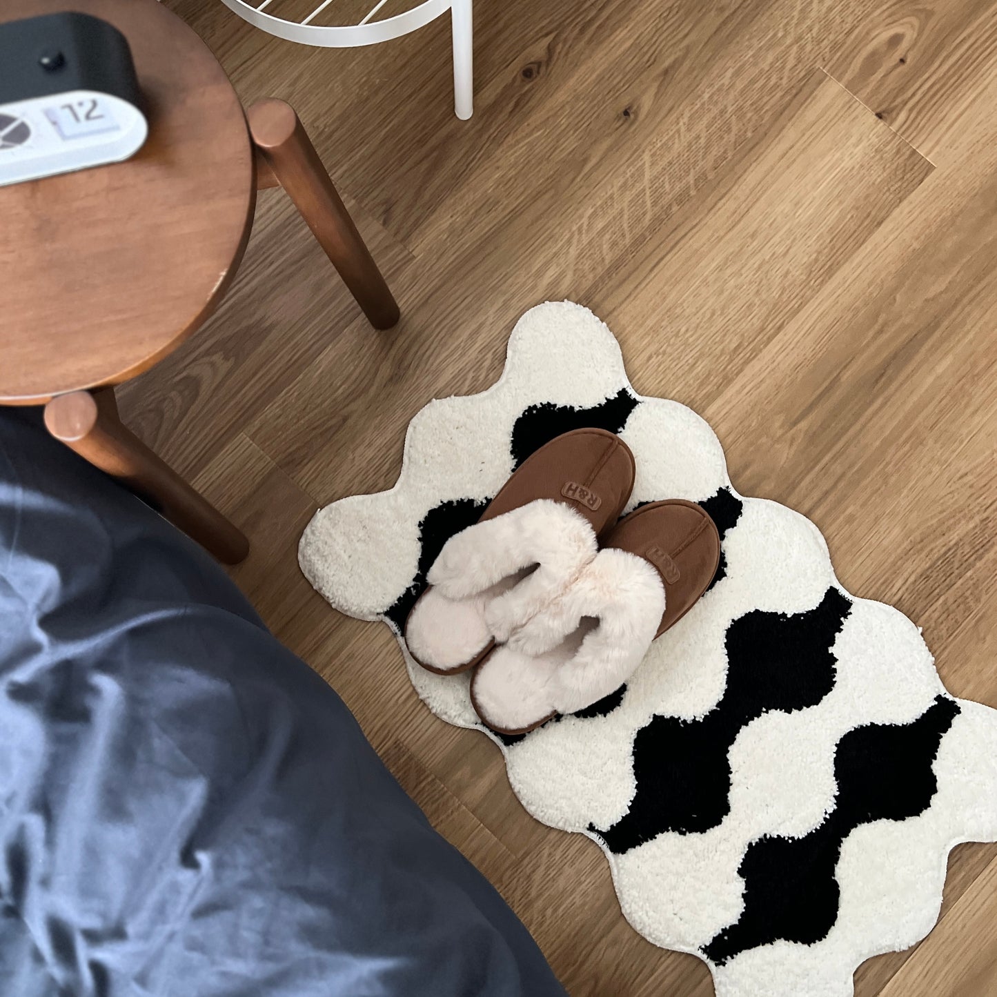 ブラウンのムートン調のファースリッパをミニラグの上に置いている様子