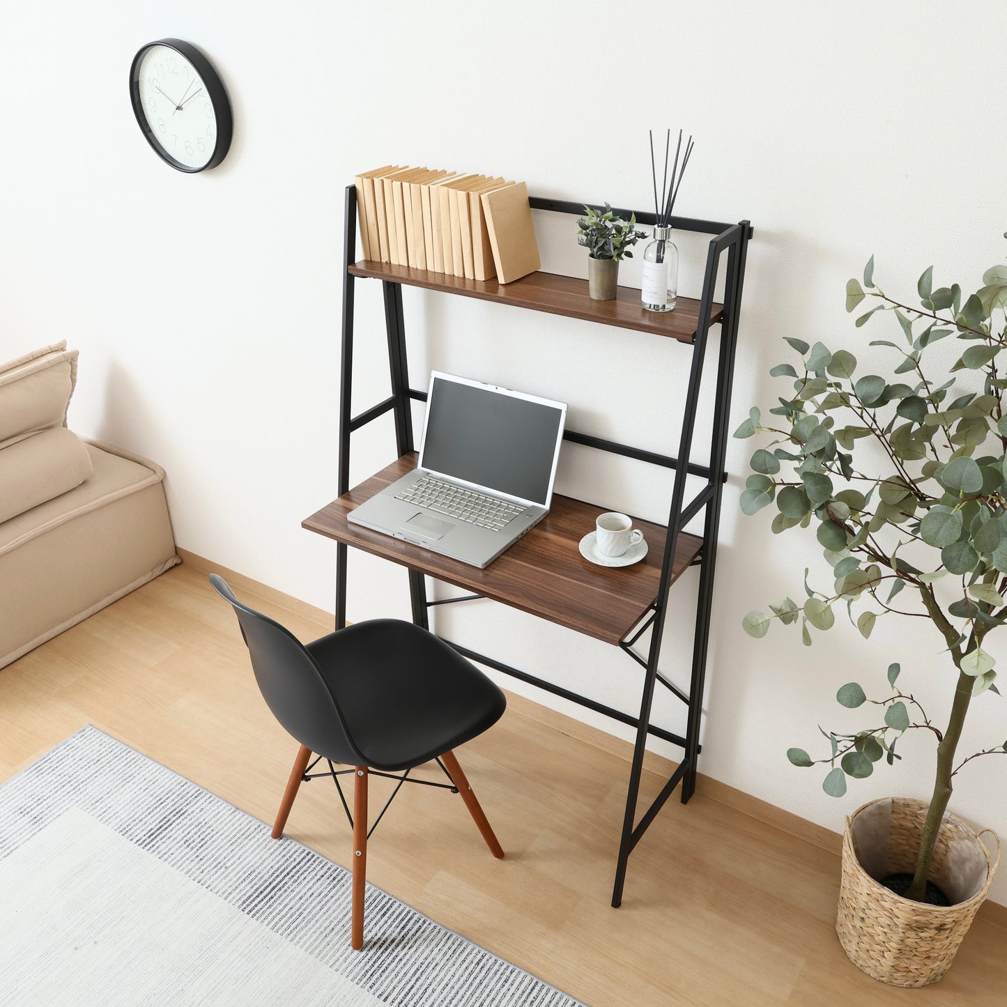 収納棚が付いた折りたたみ式のデスクにパソコンや本が置かれている様子