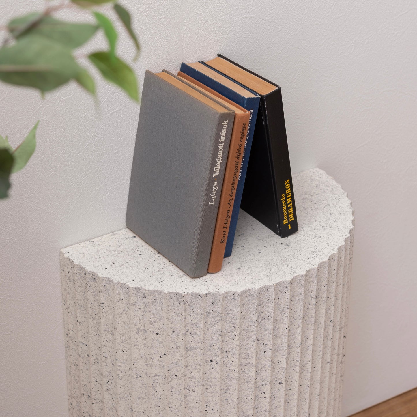 テラゾー柄の半円のスツールに本が置かれている様子