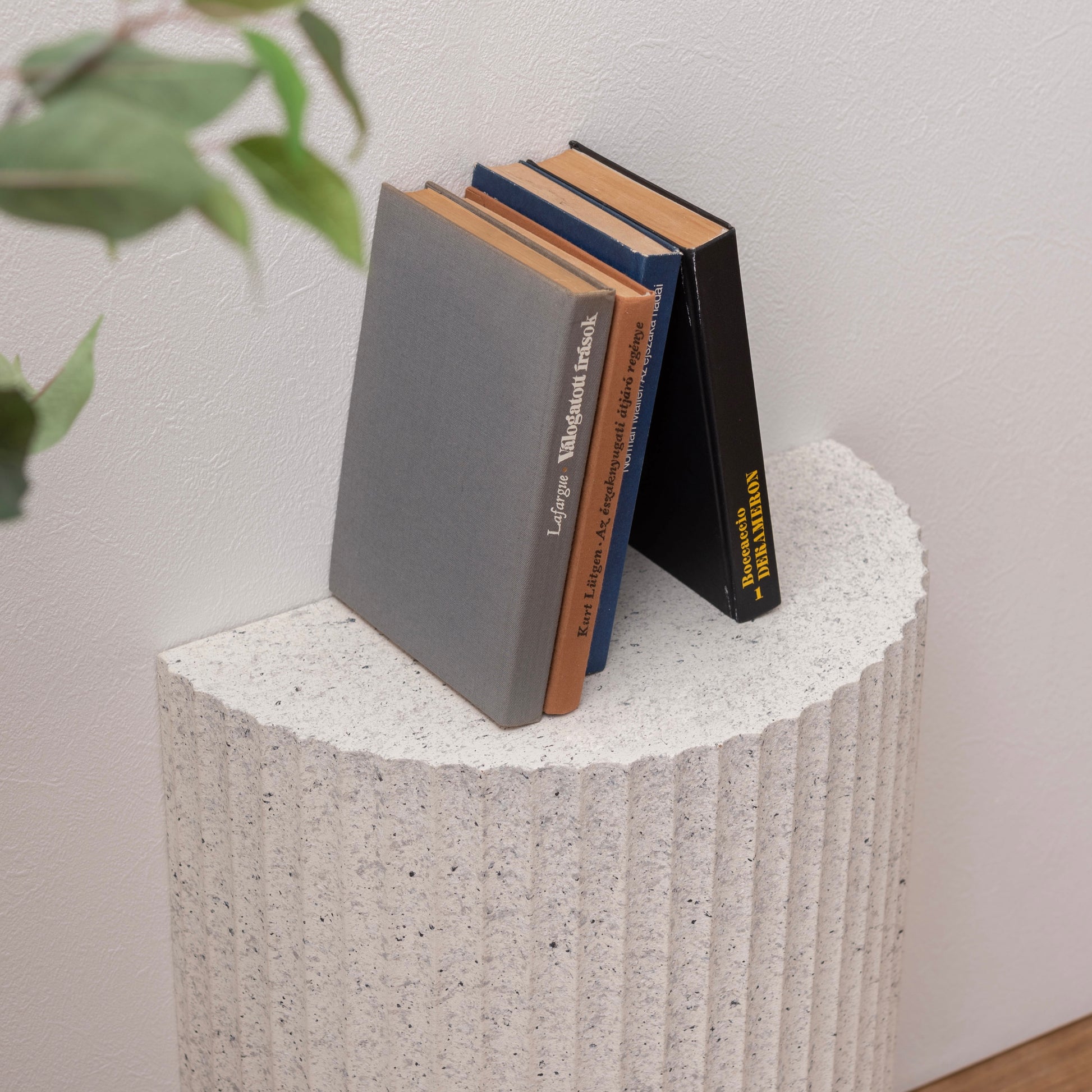 テラゾー柄の半円のスツールに本が置かれている様子