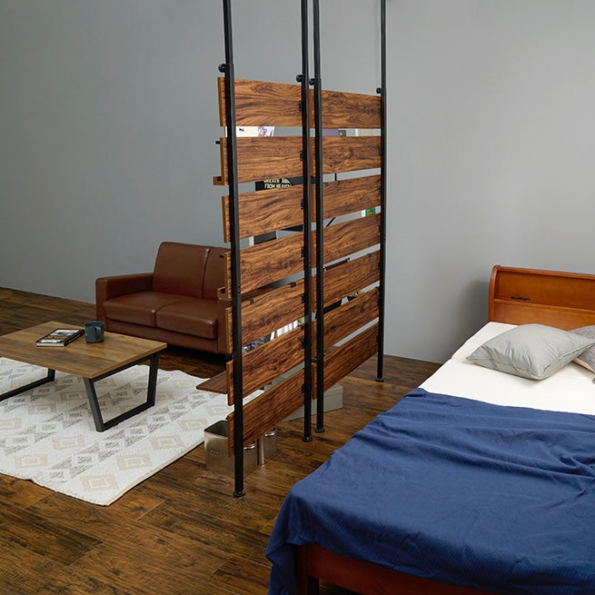 ブラウンの突っ張りディスプレイラックを2つ並べて部屋の間切りとして設置している様子