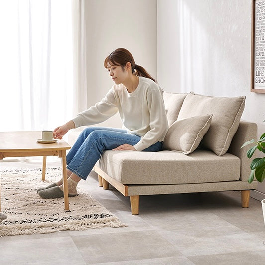 座面が広い2人掛けのソファに人が座っている様子