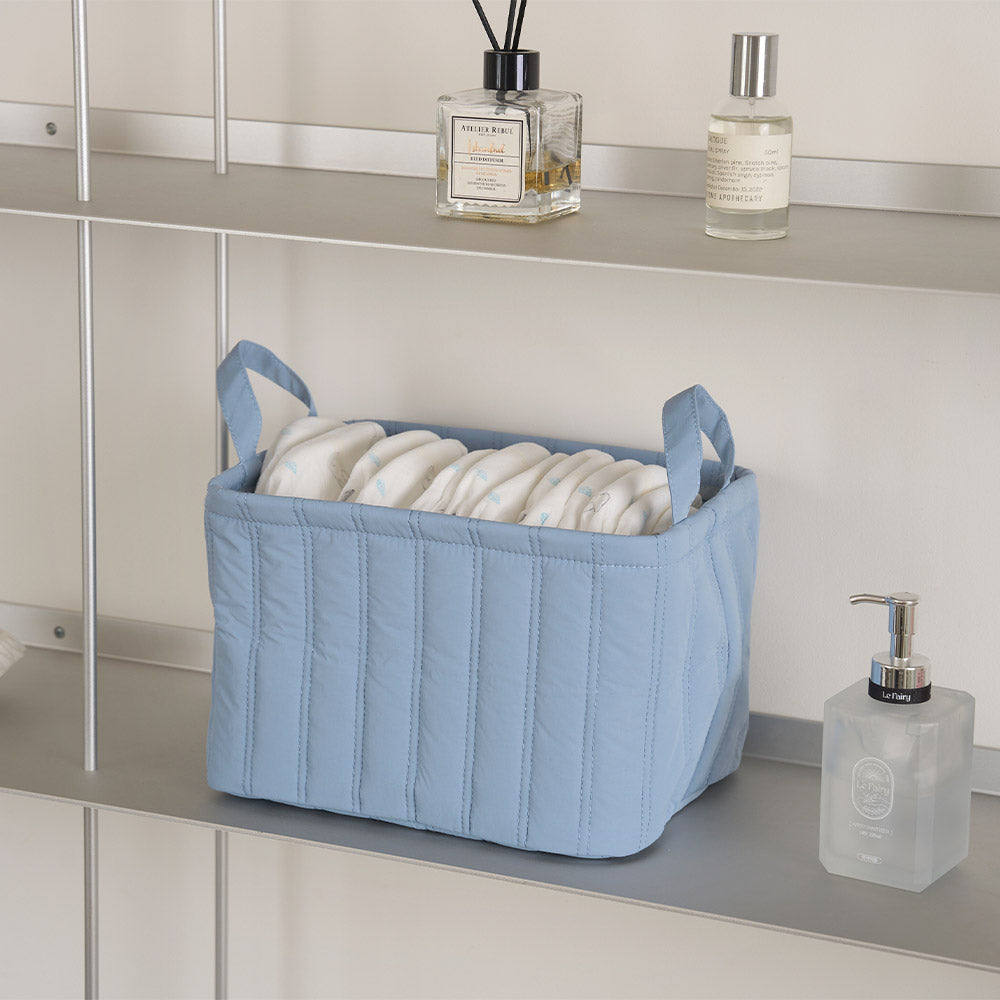 キルティング素材のブルーのバスケットにオムツが収納されている様子