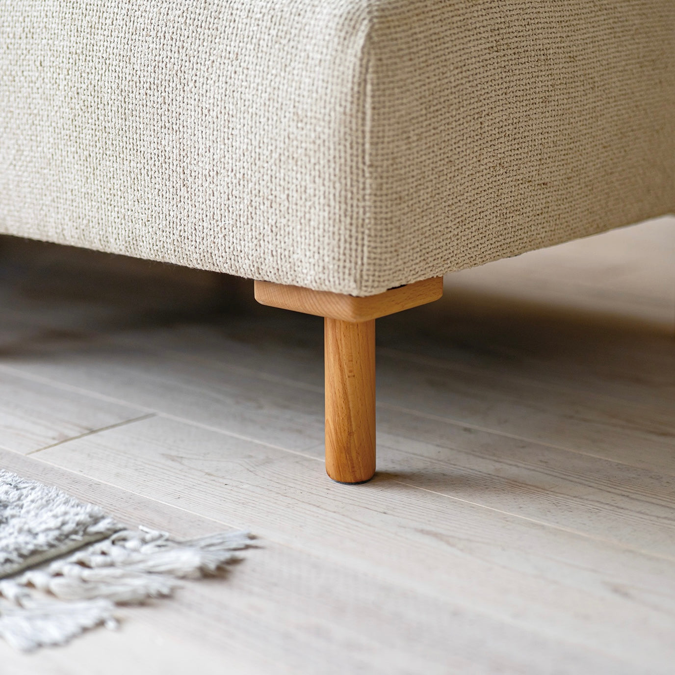 木製フレームのベージュのソファの脚部分