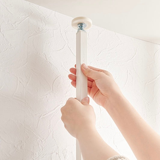 突っ張りミラー付きラックを設置している様子