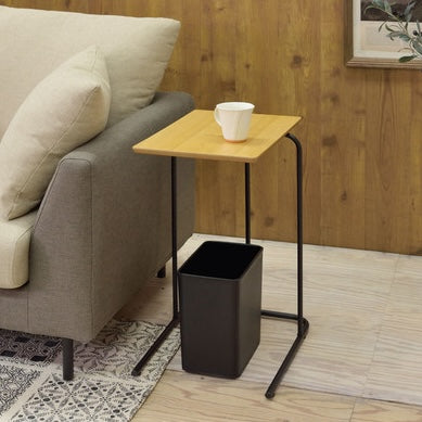 木目調の天板のコンパクトなサイドテーブルの下にゴミ箱を置いている様子
