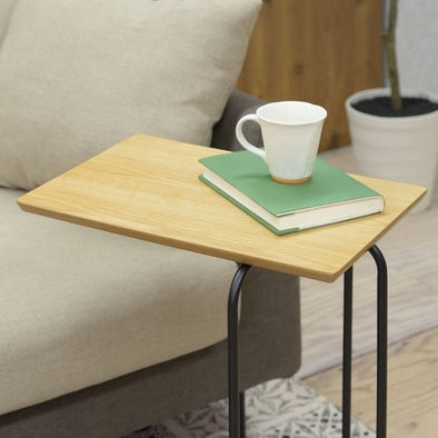 木目調の天板のコンパクトなサイドテーブルに本とマグカップを置いている様子