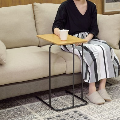 木目調の天板のコンパクトなサイドテーブルをソファのサイドテーブルとして使っている様子