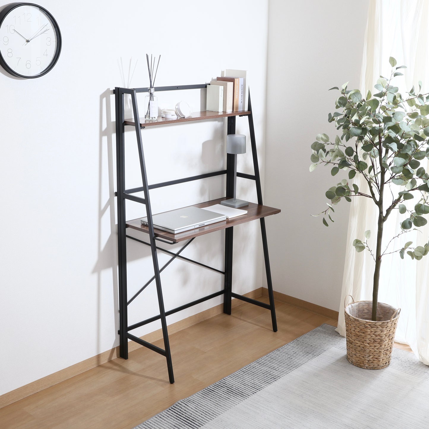 収納棚が付いた折りたたみ式のデスクにパソコンや本が置かれている様子