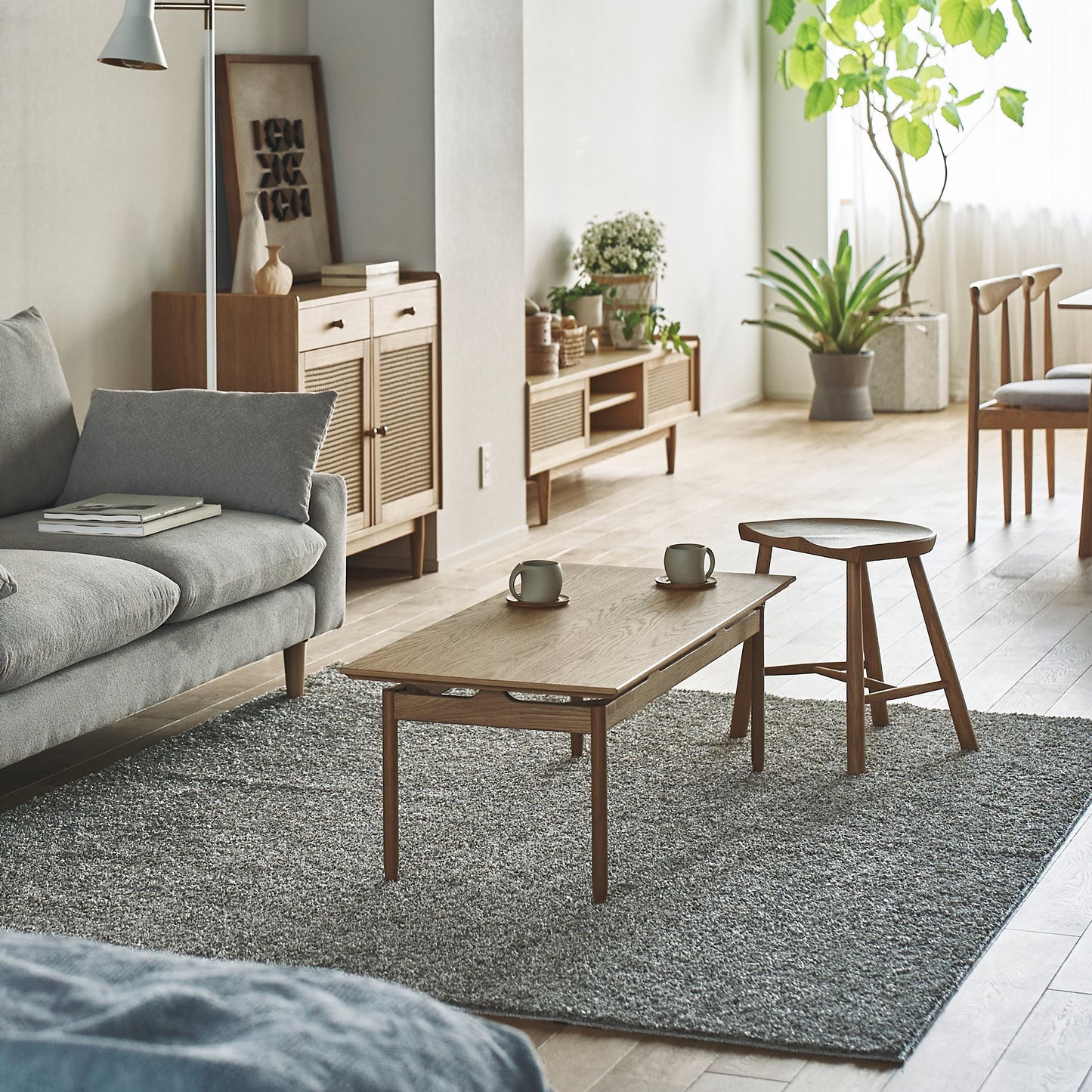 天然木の質感を生かした、シンプルな長方形のリビングテーブルがリビングの中心に置かれている