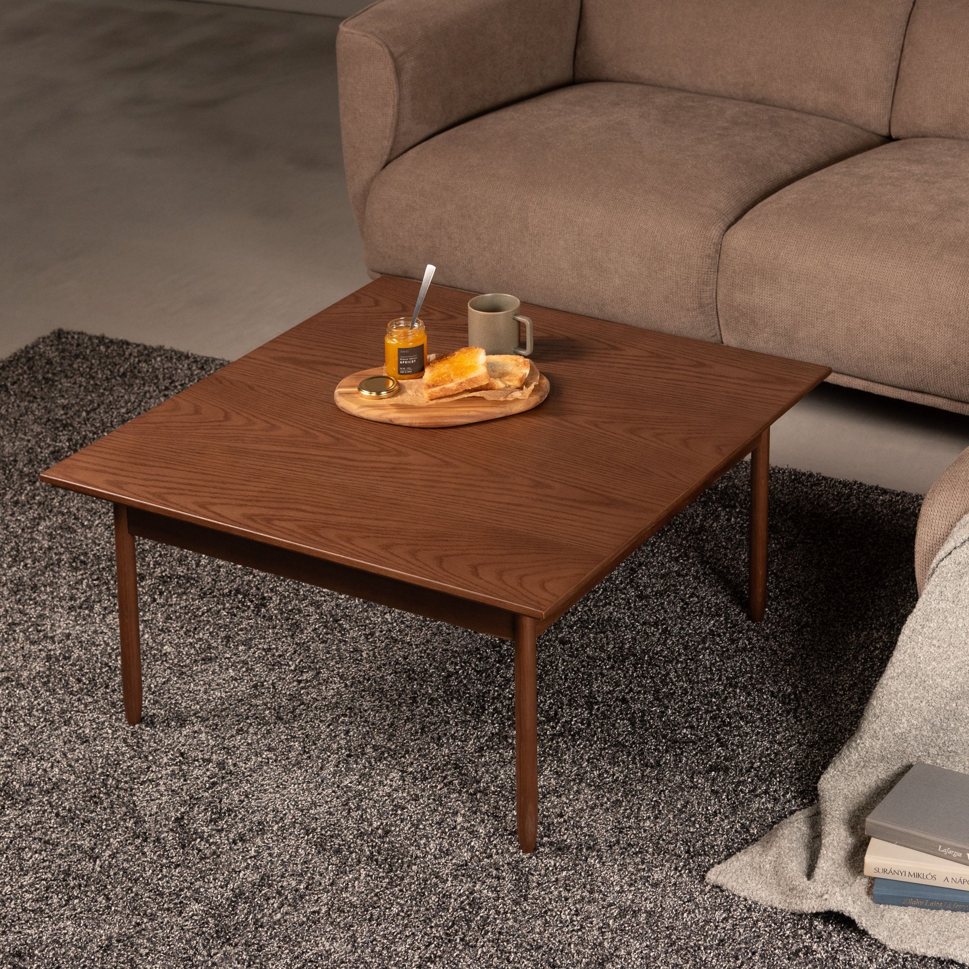 ウォルナットカラーの天然木の質感を生かした、シンプルなリビングテーブルが部屋でソファの前に置かれている