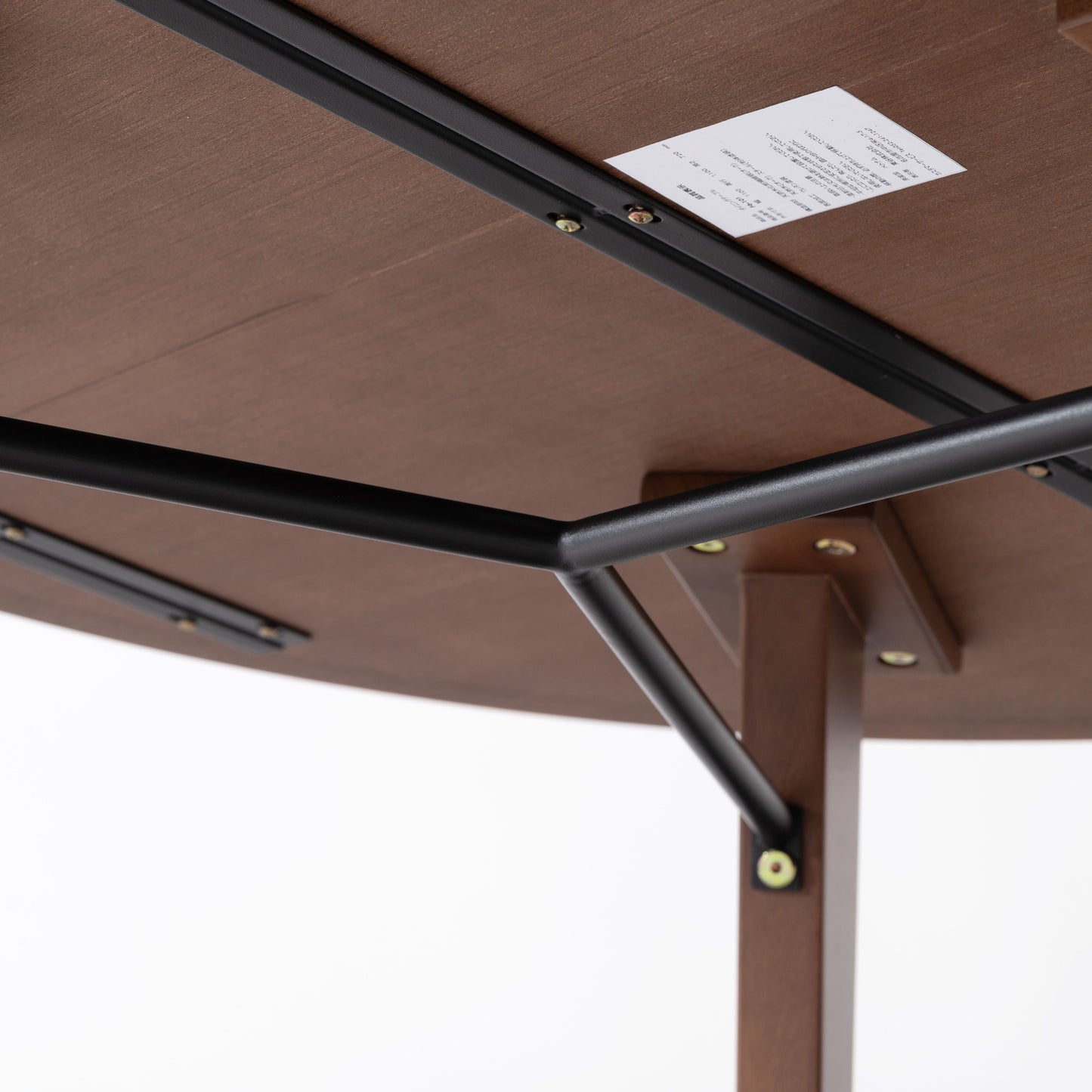 天然木の素材を使用した直径110cmの円形ダイニングテーブルのウォルナットカラーの天板裏の黒いスチール製のバーの写真