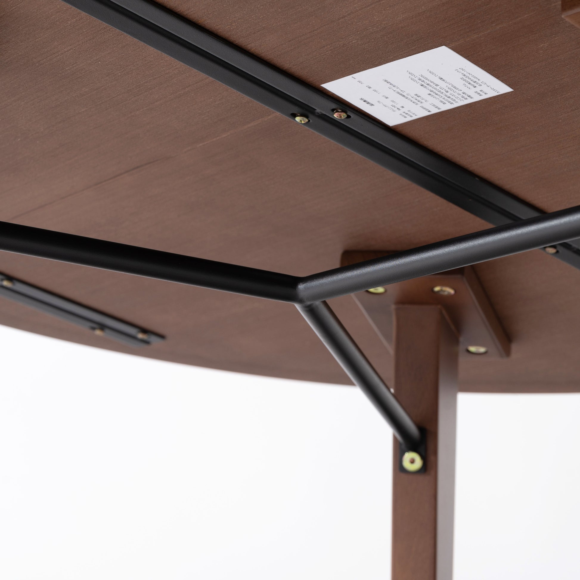 天然木の素材を使用した直径110cmの円形ダイニングテーブルのウォルナットカラーの天板裏の黒いスチール製のバーの写真