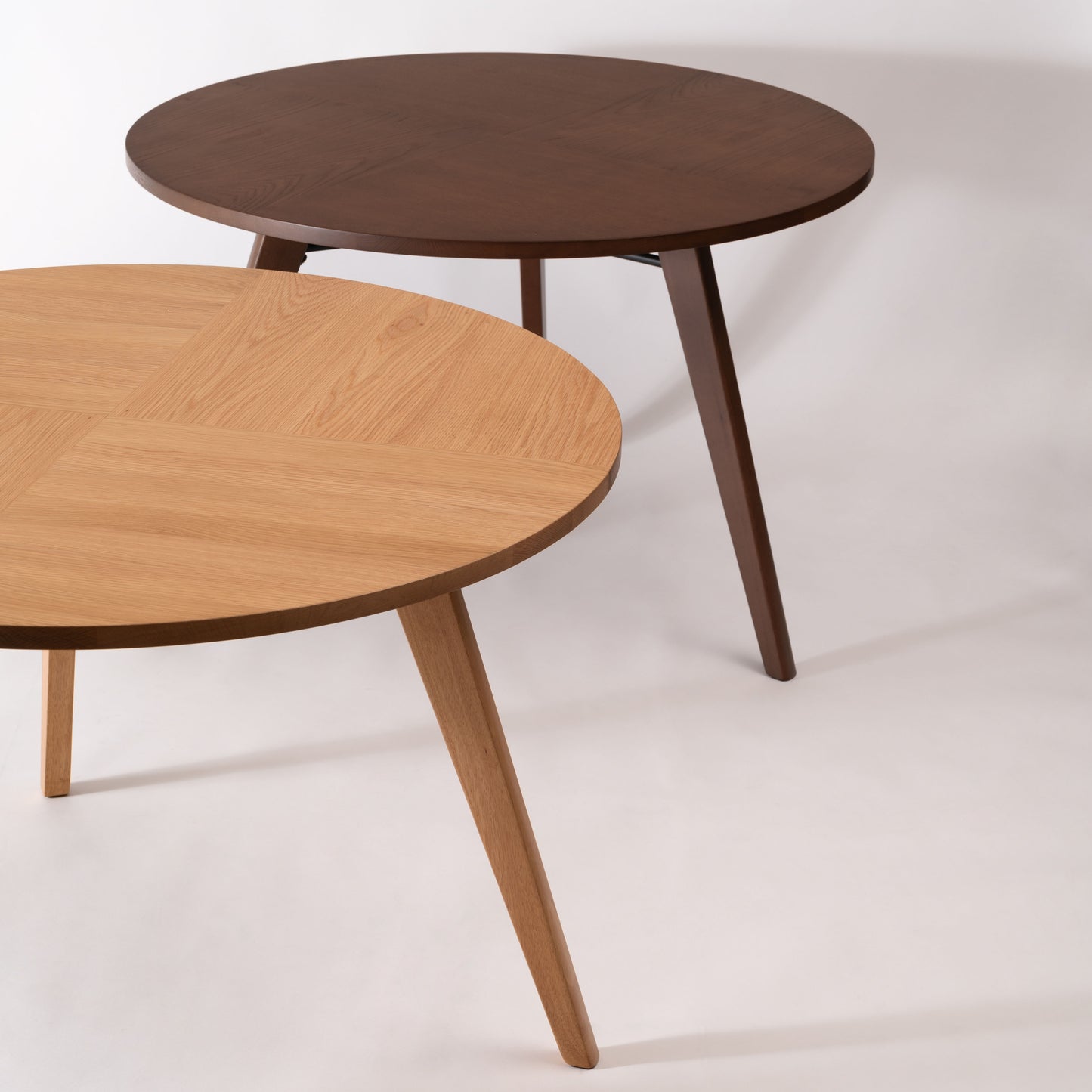 天然木の素材を使用した直径110cmの円形ダイニングテーブルのナチュラルとウォルナットカラーが2台並んでいる写真