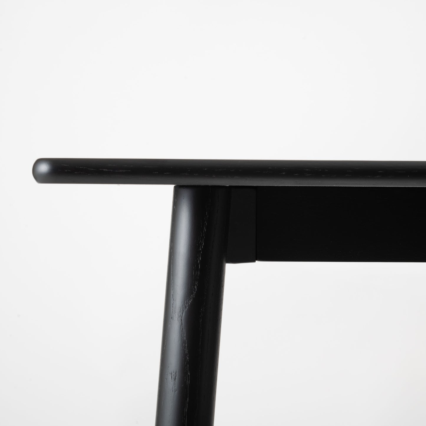 天然木オーク材を天板と脚部に使用しウレタン塗装でブラックに塗られたワントーンデザインのダイニングテーブルの天板を真横から見た写真