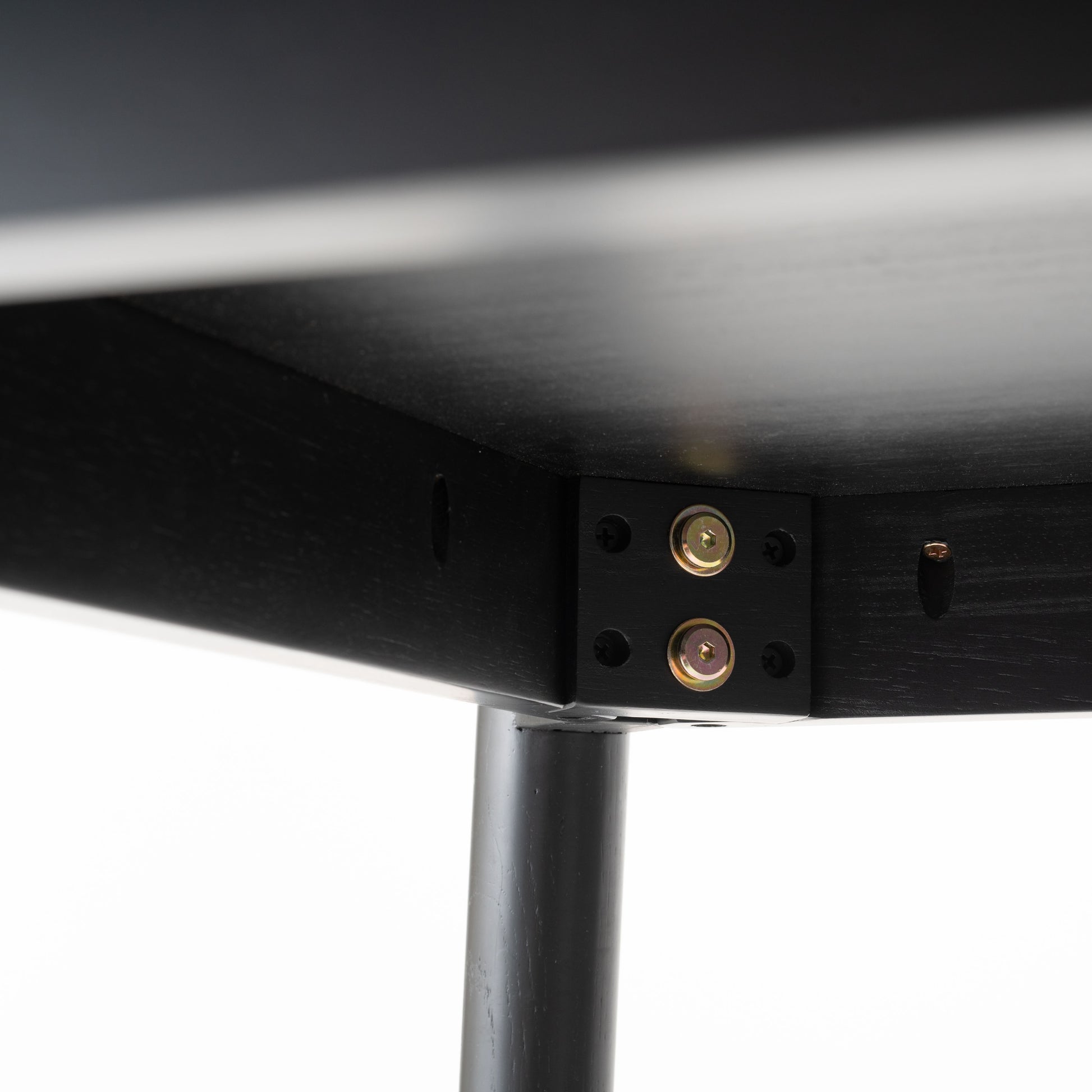 天然木オーク材を天板と脚部に使用しウレタン塗装でブラックに塗られたワントーンデザインのダイニングテーブルの天板裏の留め具の写真