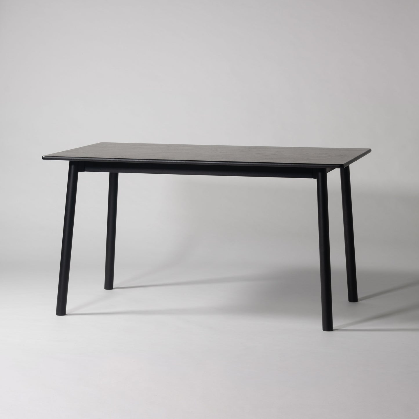 天然木オーク材を天板と脚部に使用しウレタン塗装でブラックに塗られたワントーンデザインのダイニングテーブル