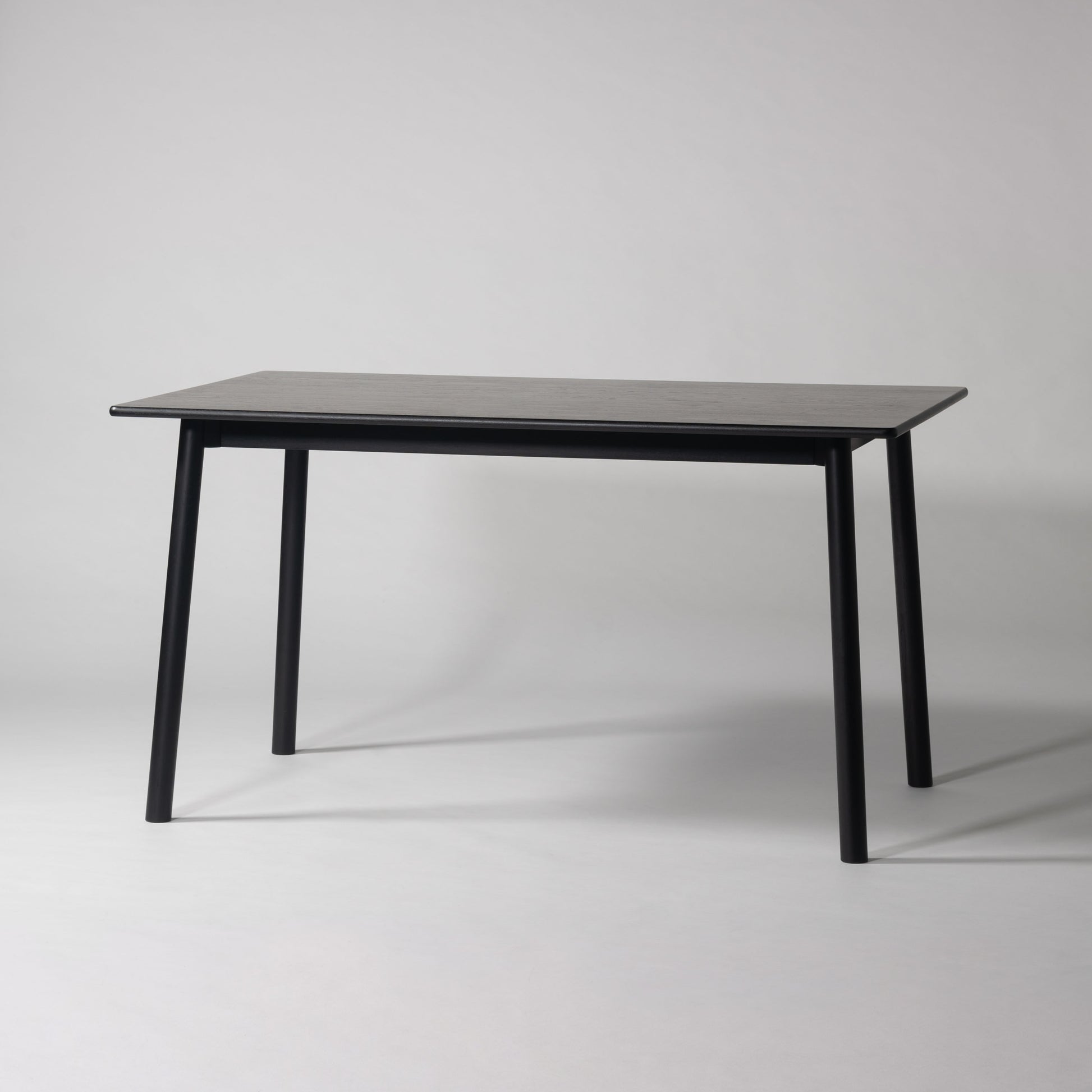 天然木オーク材を天板と脚部に使用しウレタン塗装でブラックに塗られたワントーンデザインのダイニングテーブル