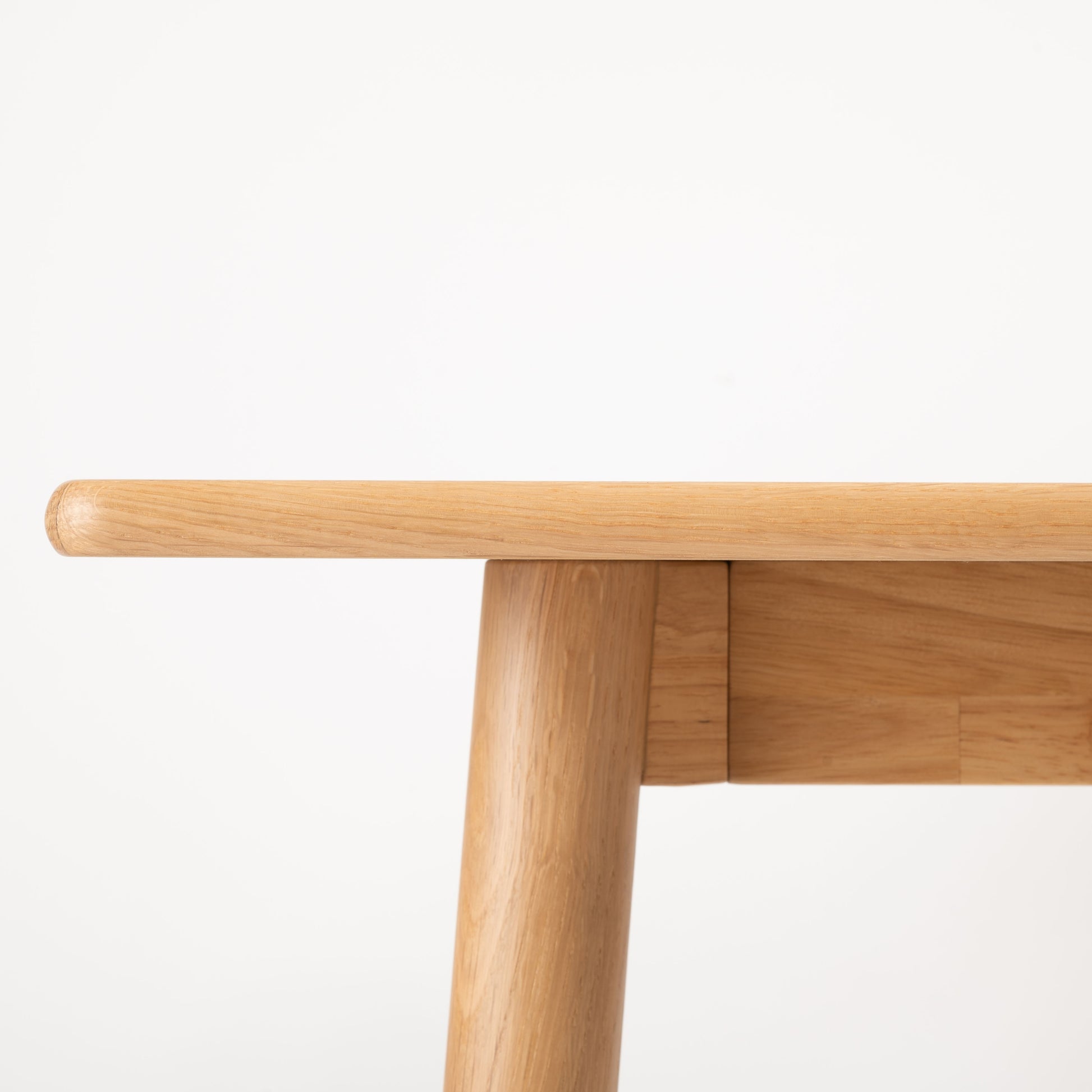 天然木オーク材を天板と脚部に使用したワントーンデザインのダイニングテーブルを真横から見た時の天板の形