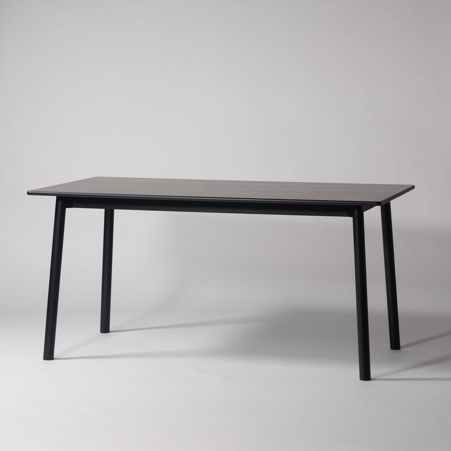 天然木オーク材を天板と脚部に使用しウレタン塗装でブラックに塗られたワントーンデザインのダイニングテーブル