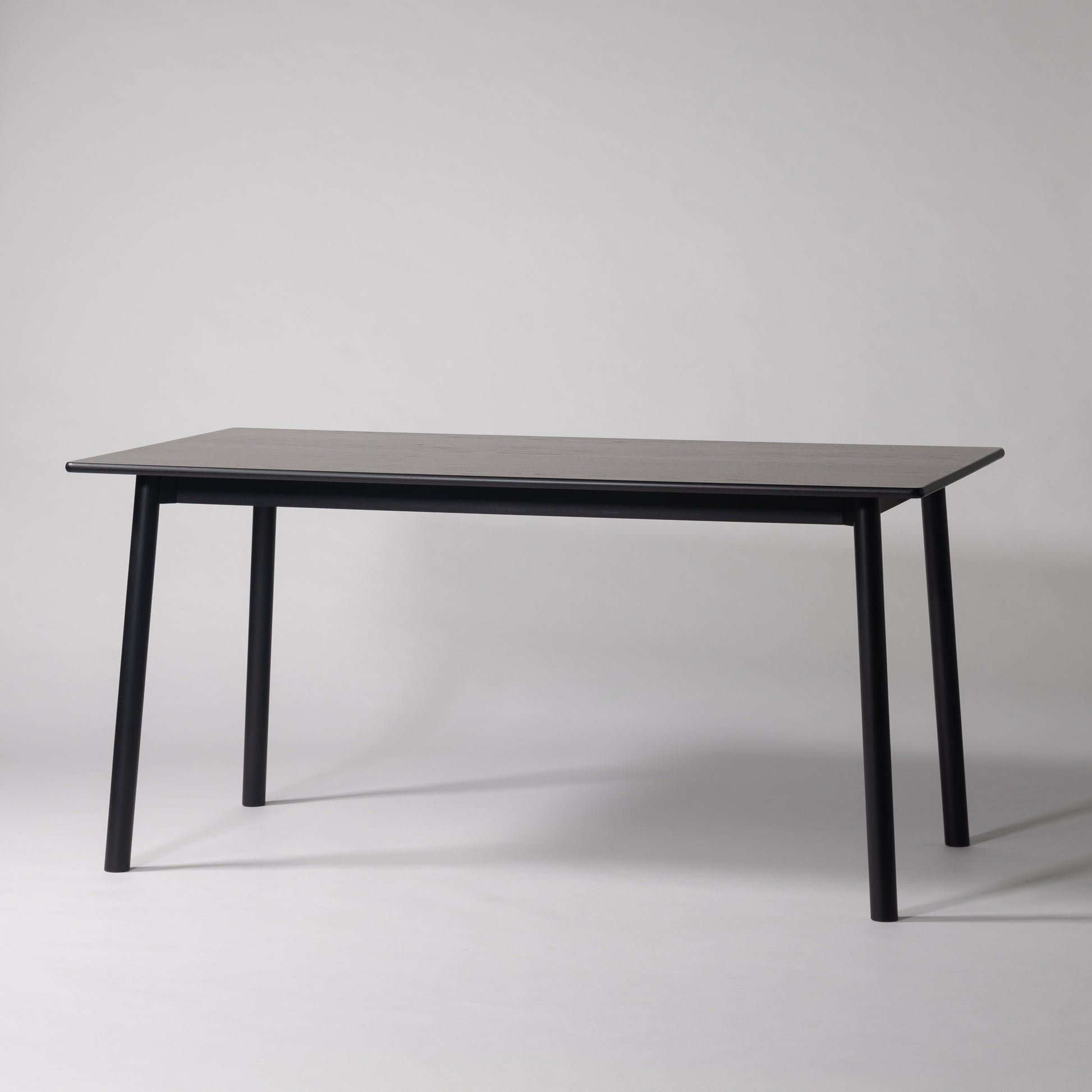 天然木オーク材を天板と脚部に使用しウレタン塗装でブラックに塗られたワントーンデザインのダイニングテーブル