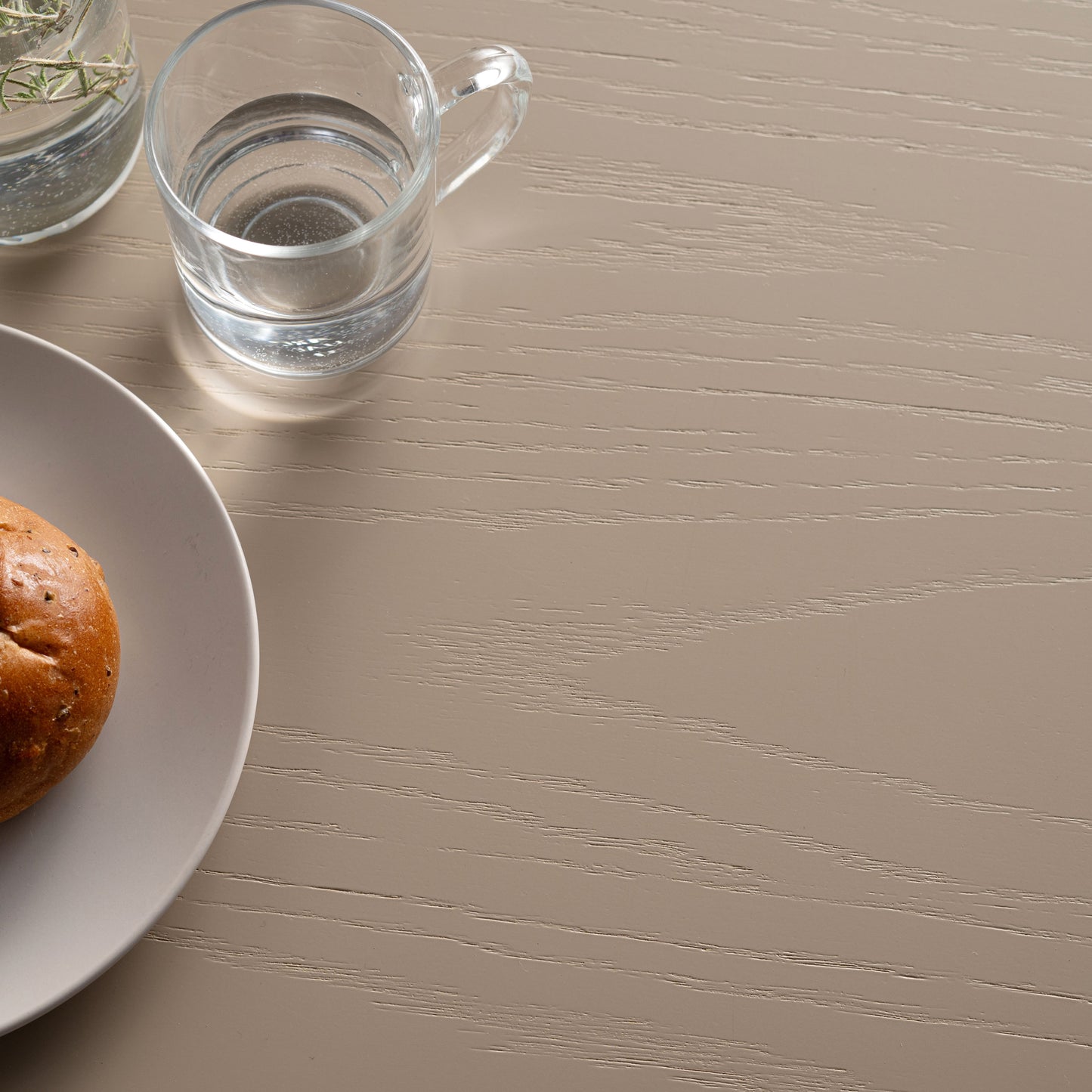 天然木オーク材を天板と脚部に使用しウレタン塗装でグレーに塗られたワントーンデザインのダイニングテーブルの天板の木目のアップ